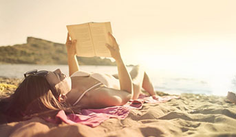 Frau mit Buch am Strand